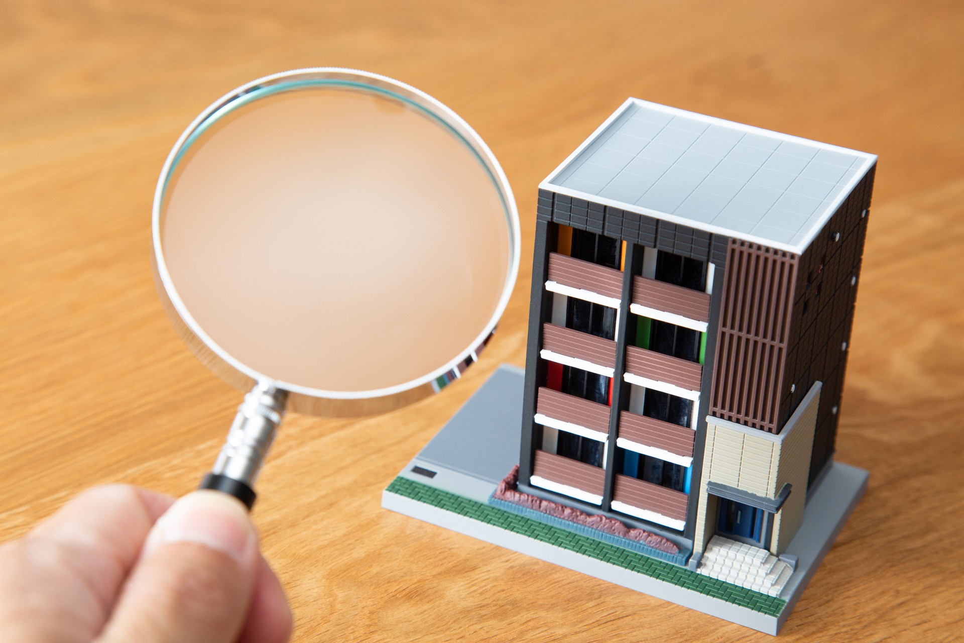 Apartment house and magnifying glass.